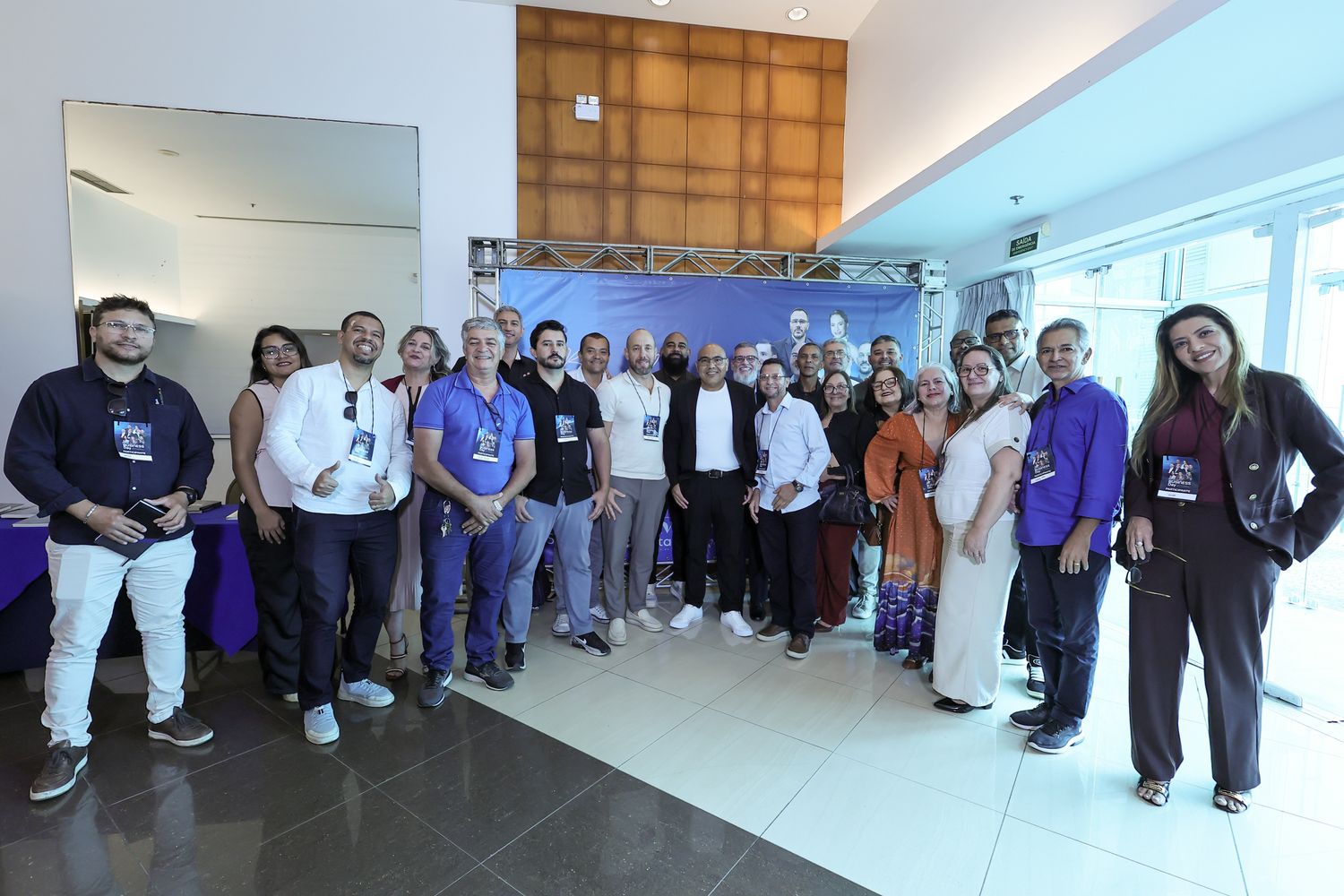 Participantes reunidos em roda no saguão do evento