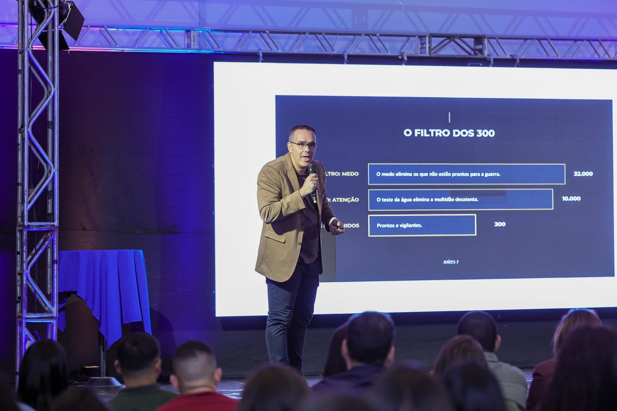 Everton Lopes no palco apresentando o slide O Filtro dos 300